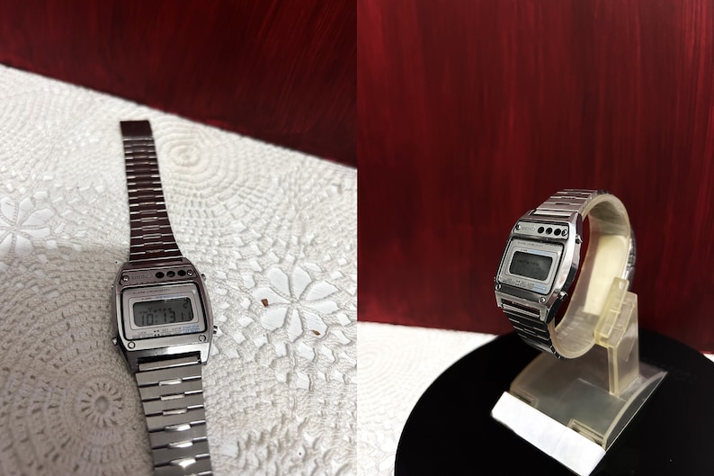 Puede incluir: Un reloj de pulsera digital plateado con una correa de metal plateado. La esfera del reloj muestra la hora y la fecha.