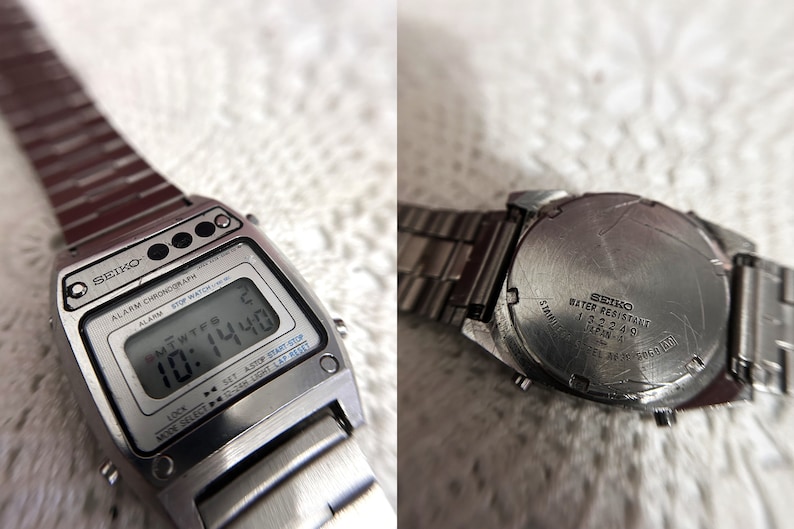 Puede incluir: Un reloj digital Seiko plateado con una esfera negra y una correa de metal plateado. El reloj tiene funciones de cron&oacute;grafo, alarma y cron&oacute;metro. La esfera del reloj muestra la hora, la fecha y el d&iacute;a de la semana. La parte posterior del reloj tiene el texto "SEIKO WATER RESISTANT 132249 JAPAN A" grabado en &eacute;l.