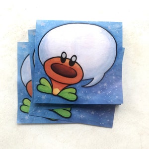 May include: A stack of blue and white stickers with a cartoon character. The character has a large white head with a speech bubble, a red and orange body, and green leaves. The background is blue with white stars.