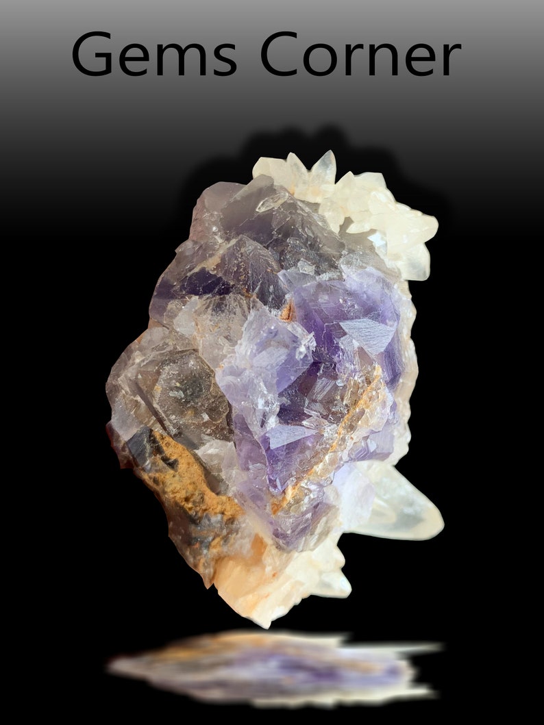 May include: A cluster of purple fluorite crystals with clear quartz crystals. The fluorite crystals have a deep purple color and are translucent. The quartz crystals are clear and have a glassy luster.