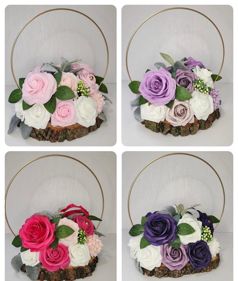 May include: Four floral arrangements on wood slices with gold hoops. The arrangements feature pink, purple, and red roses with white and lavender accents.