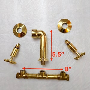 May include: Gold-toned bathroom faucet with a 5.5 inch tall spout and an 8 inch long pipe. The faucet has a round base and a round handle.