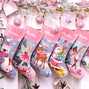 May include: A row of five personalized Christmas stockings featuring pink velvet cuffs with embroidered names Santana, Bertha, Ellison, Pasha, and Amelia. Each stocking displays a unique needlepoint holiday scene including a polar bear, ballerina, reindeer, Santa Claus, and a dancer, all accented with festive pink ornaments.