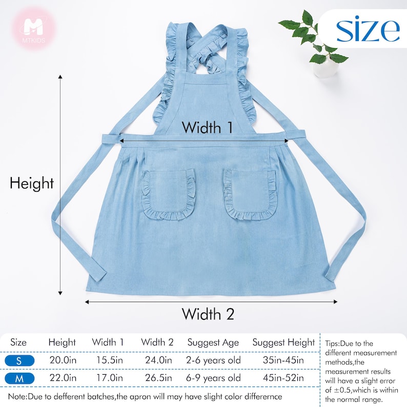 May include: A light blue denim apron with ruffled trim and two pockets. The apron has adjustable straps that cross at the back. The apron is available in two sizes: S (20 inches tall, 15.5 inches wide) and M (22 inches tall, 17 inches wide).