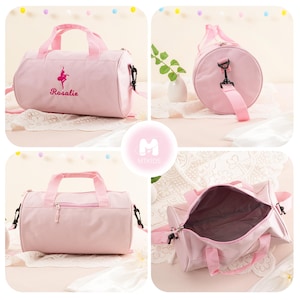 Pu&ograve; includere: Una borsa da viaggio rotonda in tela rosa con chiusura a zip e una tracolla. La borsa ha una piccola ballerina ricamata e il nome "Rosalie" sul davanti.