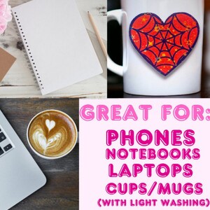 May include: A white spiral-bound notebook with blank pages, a pencil, and a coffee cup with latte art. A white mug with a heart-shaped sticker and the text "GREAT FOR: PHONES NOTEBOOKS LAPTOPS CUPS/MUGS (WITH LIGHT WASHING)" is also visible.