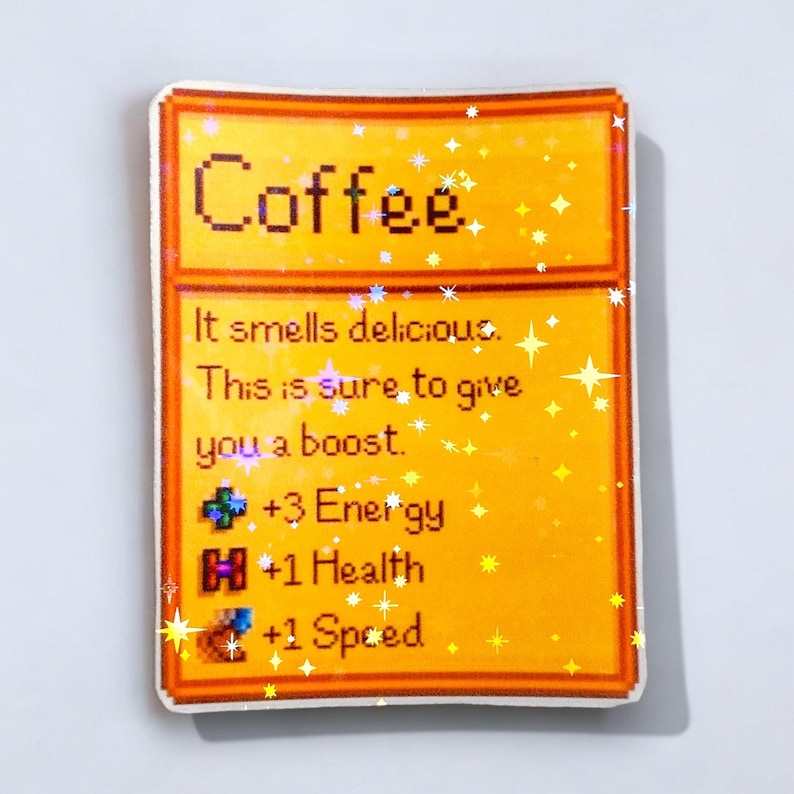 May include: A rectangular sticker with a yellow background and a brown border. The word "Coffee" is at the top. Below, text reads "It smells delicious. This is sure to give you a boost." with game stats: +3 Energy, +1 Health, and +1 Speed.
