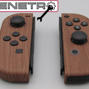Könnte beinhalten: Ein Paar braune, hölzerne Nintendo Switch Joy-Con-Controller mit schwarzen Knöpfen und Analogsticks. Die Controller sind getrennt und zeigen das Schienensystem, das sie verbindet.