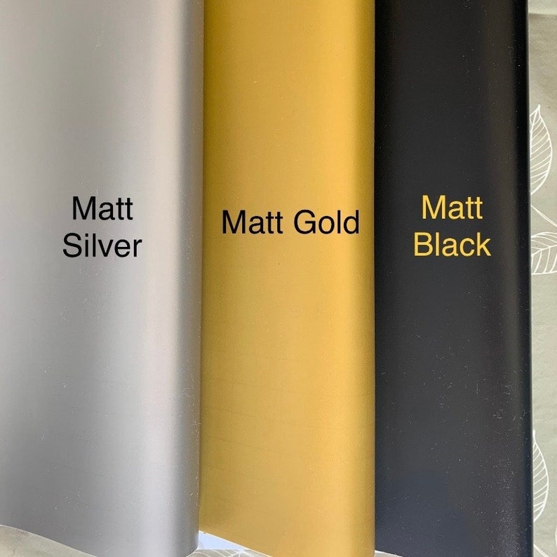 Op de afbeelding: Drie voorbeelden van vinylfolie in verschillende kleuren: Matt Zilver, Matt Goud en Matt Zwart.