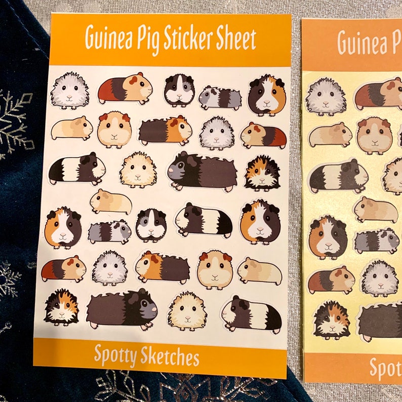 May include: A sheet of stickers featuring various guinea pig designs. The stickers are colourful and feature different poses and expressions. The sheet is titled "Guinea Pig Sticker Sheet" and "Spotty Sketches".
