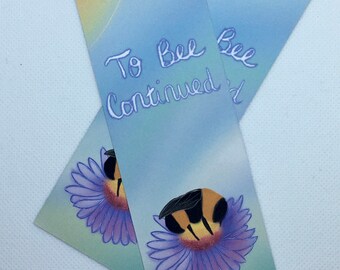 May include: Two blue and yellow bookmarks with the text "To Bee Continued" and a bee on a purple flower.