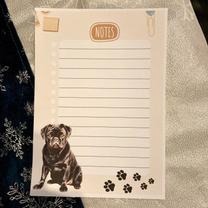 May include: A printable notepad featuring a black pug dog illustration with paw prints at the bottom. The notepad has a brown title bar with the word "NOTES" in white text.