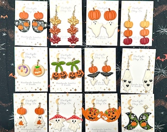 Può includere: Un set di 10 paia di orecchini in argilla polimerica a tema Halloween. Gli orecchini presentano vari design, tra cui zucche, fantasmi, pipistrelli e foglie. Gli orecchini sono fatti a mano e sono montati su ganci per orecchini dorati.