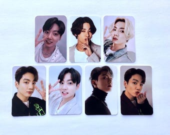 May include: Seven rectangular photo cards featuring a young man in various poses and outfits. The cards showcase the man with different hairstyles, including black and blonde, and various expressions, such as peace signs and blowing kisses.