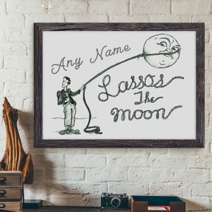 May include: A black and white illustration of a person lassoing the moon. The text "Any Name Lassos the Moon" is written in a cursive font.