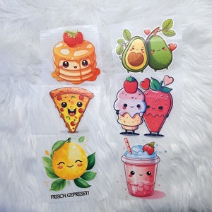 Könnte beinhalten: Fünf Bügelbilder mit niedlichen Comicfiguren. Die Patches zeigen einen Stapel Pfannkuchen, ein Stück Pizza, ein Erdbeereis-Hörnchen, zwei Avocados und einen Erdbeer-Milchshake. Die Patches sind alle auf weißem Hintergrund.