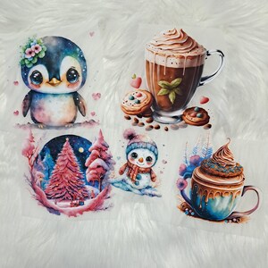 Könnte beinhalten: Vier Illustrationen zum Thema Winter: ein Pinguin mit blauen und violetten Federn, ein Schneemann mit rotem Schal, ein rosa Weihnachtsbaum und eine blaue Tasse mit brauner Schokoladen-Topping.