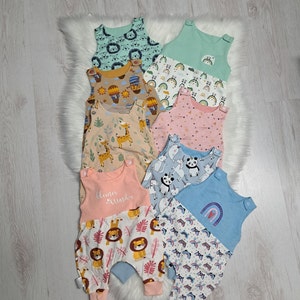 May include: A stack of eight colorful baby onesies with different animal and rainbow patterns. The onesies are made of soft, comfortable fabric and are perfect for everyday wear.