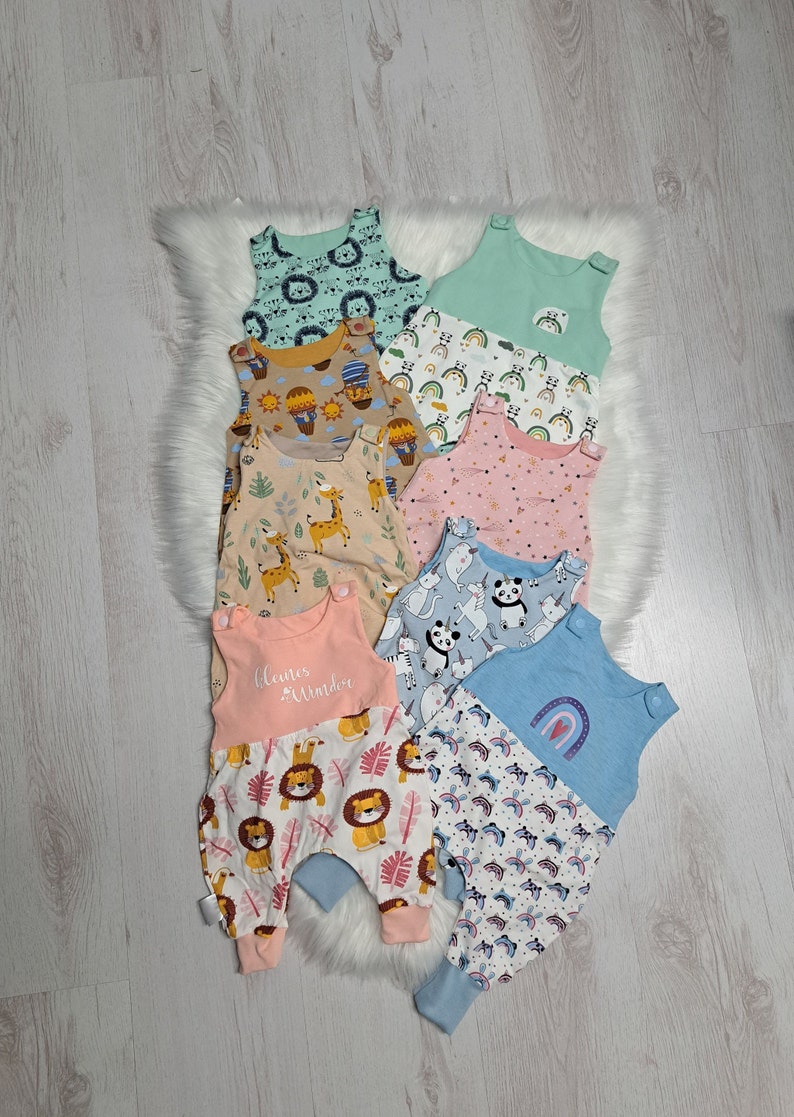 May include: A stack of eight colorful baby onesies with different animal and rainbow patterns. The onesies are made of soft, comfortable fabric and are perfect for everyday wear.