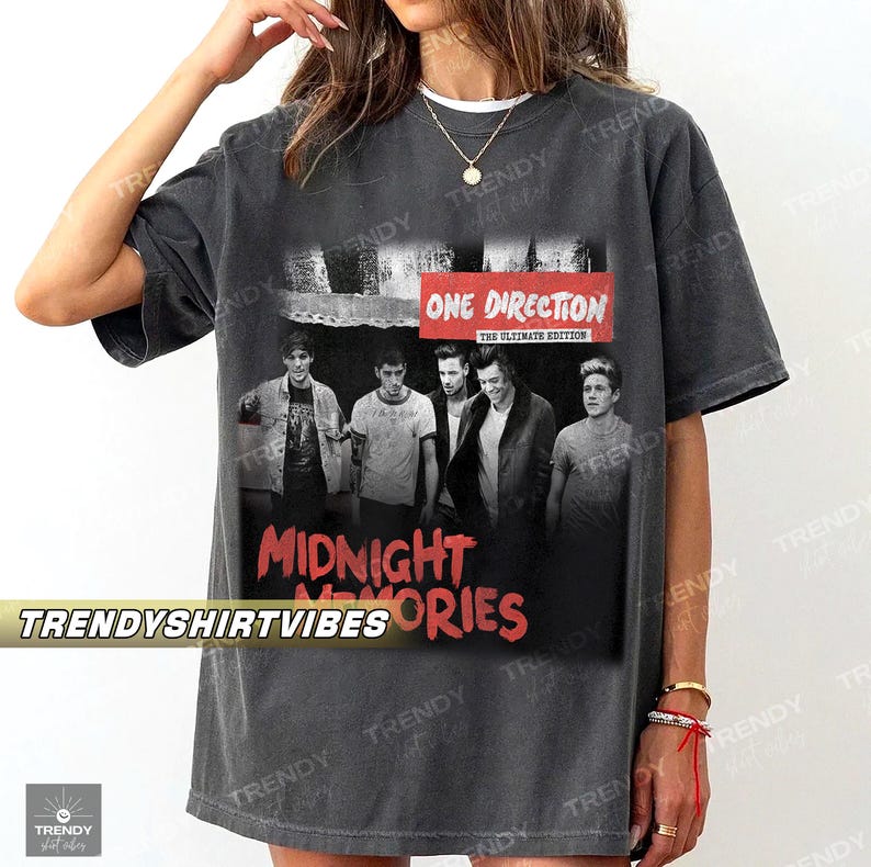 A person wearing a grey t-shirt with a graphic design featuring the members of the British pop group One Direction.