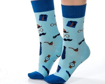 May include: A pair of blue and light blue socks with a pattern of mustaches, ties, hats, glasses, and pocket watches.