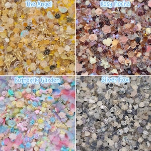 Pu&ograve; includere: Una collezione di quattro set distinti di piccoli ciondoli decorativi in resina con varie forme tra cui rose, farfalle, angeli, lune e fiocchi. I set sono etichettati come The Angel in oro, Rosy Mocha in marrone, Butterfly Garden in pastello e Silver Fox in grigio.