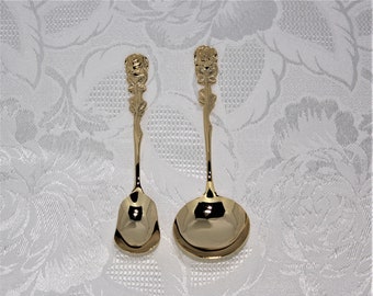 May include: Two gold-tone spoons with rose-shaped handles. The spoons have a polished finish and are ideal for serving desserts or tea.