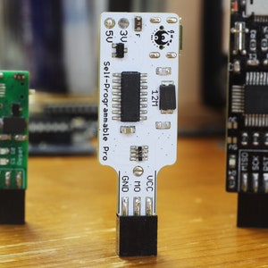 May include: Three small circuit boards with black connectors. The centre board is white with black text that reads "Self-Programmable Pro" and "12M". The board on the left is green and the board on the right is black.
