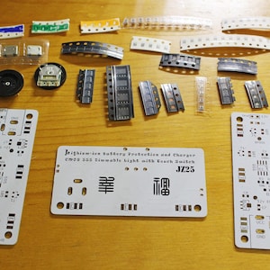 May include: An assortment of electronic components, including circuit boards, LEDs, and various chips, are arranged on a wooden surface. The boards have text that reads "Lithium-ion Battery Protection and Charger" and "JZ25".