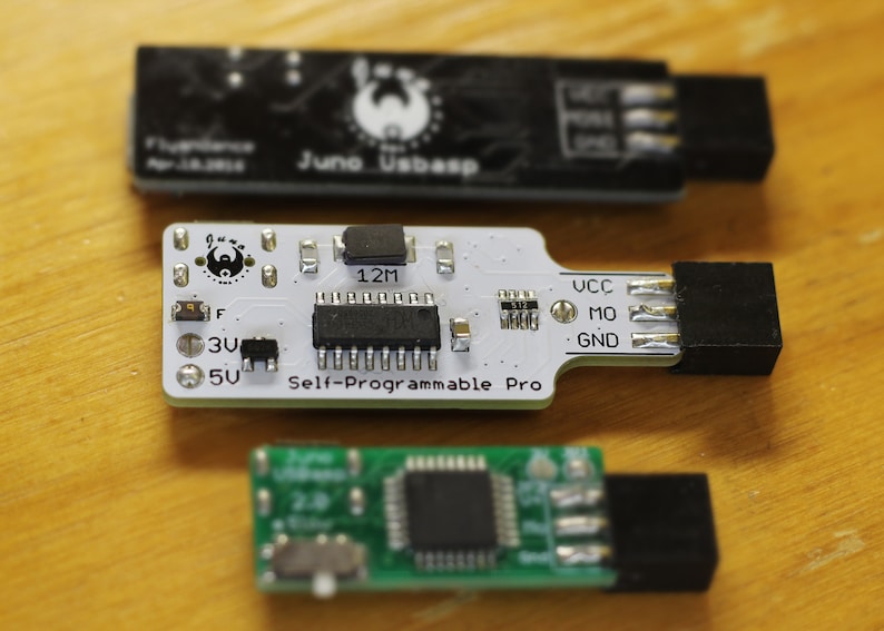 May include: Three small circuit boards, one black, one white and one green. The white board has the text "Self-Programmable Pro" printed on it. The green board has a small button on it.