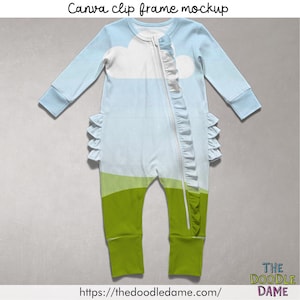May include: A light blue and white baby onesie with a cloud and landscape design. The onesie has long sleeves, a zipper down the front, and ruffle accents. The bottom half is green. The text "Canva clip frame mockup" is at the top.