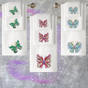 May include: Set of six white towels with embroidered butterflies. The butterflies are in various colours, including green, blue, pink, and red. Each butterfly has a floral design.
