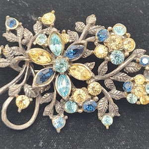 1940s Coro multicolor rhinestone floral brooch In a silver tone metal setting.