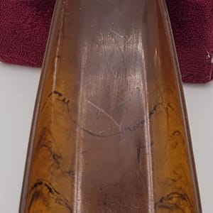 May include: A brown plastic shoe horn with a round top featuring the text "The Florsheim Shoe" in a white circle with a stylized "F" in the center.