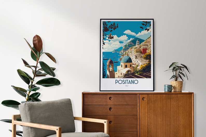 May include: A vintage-style travel poster featuring a colorful illustration of Positano, Italy. The poster depicts a seaside town with buildings on a hillside, a blue sky with clouds, and a blue ocean with boats. The text "Positano, Italy" is printed at the bottom of the poster.