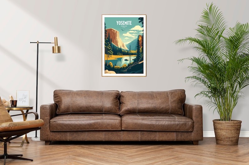 May include: A brown leather sofa with two cushions in front of a white wall with a framed poster of Yosemite National Park. The poster features a mountain range, a lake, and trees. A potted plant is on the right side of the sofa.
