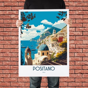 May include: A vintage travel poster featuring a colorful illustration of Positano, Italy. The poster depicts a seaside town with white buildings, a blue domed church, and a lush green hillside. The text "Positano, Italy" is printed at the bottom of the poster.