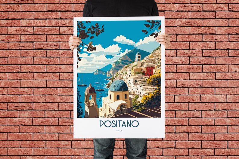 May include: A vintage travel poster featuring a colorful illustration of Positano, Italy. The poster depicts a seaside town with white buildings, a blue domed church, and a lush green hillside. The text "Positano, Italy" is printed at the bottom of the poster.