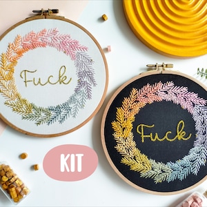May include: A DIY embroidery kit featuring two hoop embroidery patterns with a wreath of leaves and the word "F*ck" in gold glitter thread. The kit includes two embroidery hoops, fabric, thread, and needles.