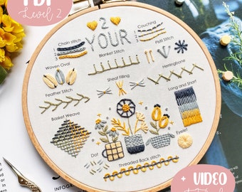 May include: A close-up of a white embroidery hoop with a variety of embroidery stitches, including chain stitch, woven oval, feather stitch, basket weave, dot, threaded back stitch, couching, pistil stitch, herringbone, long and short, and eyelet. The hoop is surrounded by a wooden frame and the text "2 YOUR" is embroidered in the centre. The text "PDF Level 2" is visible in the top left corner of the image. The text "VIDEO tutorial" is visible in the bottom right corner of the image.