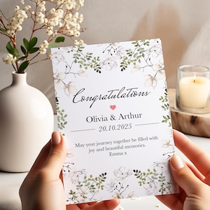 カップルのための花柄ウェディングまたは婚約カード。名前、日付、メッセージがパーソナライズされ、エレガントなお祝いカードとして、記念品としてギフトとして贈れます。