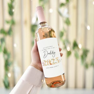 May include: A bottle of ros&eacute; wine with a light pink hue, featuring a white label with the text "ON YOUR FIRST FATHER'S DAY AS MY Daddy 2025 LOVE FROM ALFIE X". The bottle has a pale pink cap.