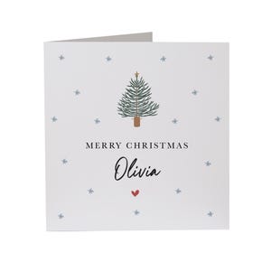 May include: A white Christmas card with a green Christmas tree illustration and the text "Merry Christmas Olivia" with a red heart.
