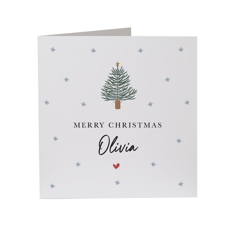 May include: A white Christmas card with a green Christmas tree illustration and the text "Merry Christmas Olivia" with a red heart.