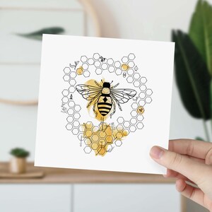 May include: A black and white illustration of a bee in a honeycomb pattern with a yellow watercolor wash. The bee is in the center of the honeycomb and has its wings spread out.