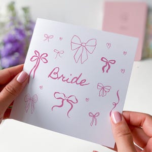 Carte de la mariée avec un joli nœud rose, une carte amusante pour un mariage ou un enterrement de vie de jeune fille, de la mariée, de la demoiselle d'honneur, d'un ami ou d'une soeur