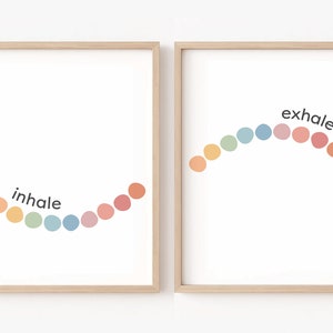 May include: Two framed prints with a rainbow of coloured circles arranged in an arc. The left print says "inhale" and the right print says "exhale".