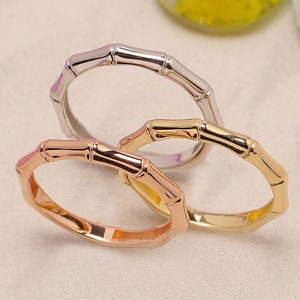 May include: Three bamboo-style rings in different metal finishes: gold, rose gold, and silver.
