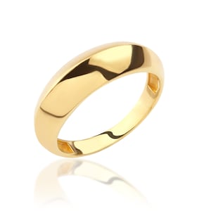 May include: A simple gold band ring with a smooth, rounded surface.