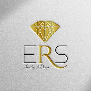 Könnte beinhalten: Goldenes Diamant-Logo mit den Buchstaben ERS in einer Serifenschrift. Darunter der Text "Jewelry & Design" in einer Schreibschrift. Das Logo befindet sich auf einem strukturierten weißen Hintergrund.